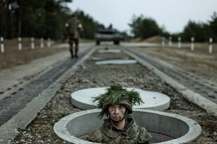 Soldat guckt aus einem Schacht