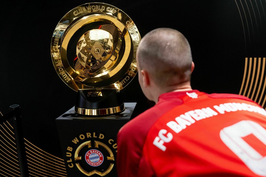 Fan im FC Bayern-Trikot betrachtet die Trophäe, die der Sieger der Klub-WM erhalten wird