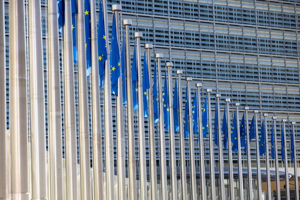 Eine Flaggenreihe mit dem Symbol der Europäischen Union vor dem Gebäude der Europäischen Kommission in Brüssel.