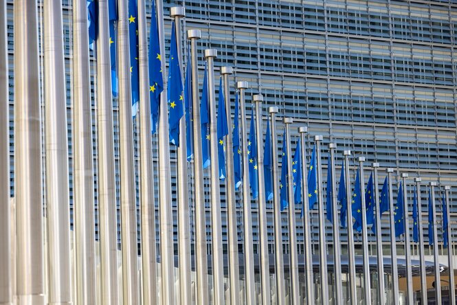 Eine Flaggenreihe mit dem Symbol der Europäischen Union vor dem Gebäude der Europäischen Kommission in Brüssel.