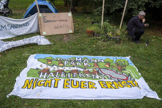 Ein auf dem Boden ausgebreitetes Transparent: "Thälmannpark halbieren – nicht euer Ernst"