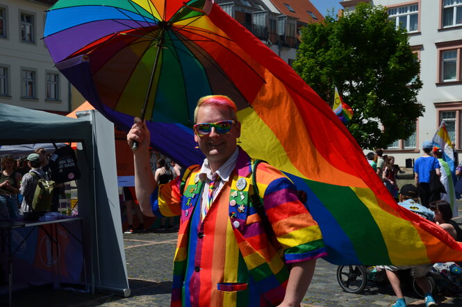 Regebogenschirm, Regenbogenjacke und Regebogenhaare: Olaf Wunderbar fällt auf