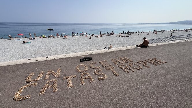 Tausende Zigarettenstummel formen den Schriftzug "UN Ocean Catastrophe" am Badestrand von Nizza