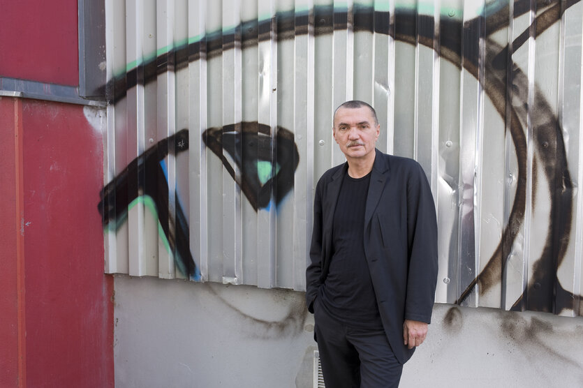 Wolfgang Engler vor einer Wellblechwand mit Graffiti