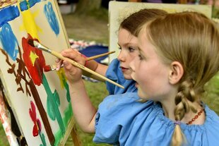 Kinder in Kitteln malen bunt