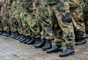 Zu sehen sind die Beine von Bundeswehrsoldaten in Uniform bei einer Aufstellung.