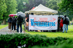Mehrere Personen demonstrieren in der Zitadelle Vechta gegen einen Reservistenappell mit Schwurbekräftigung im Rahmen des Nationalen Veteranentags.