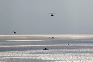 Helicopter, ein U-Boot und ein Militärschiff im weiten meer