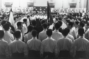 Ein historisches Foto zeigt eine große Menschengruppe, die gemeinsam singt