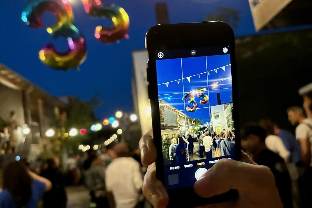 Ein Fotograf, der mit dem Handy eine Feierszene fotografiert