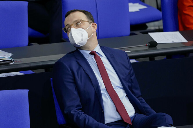 Jens Spahn trägt eine FFP2-Maske und sitzt auf der Regierungsbank im Bundestag