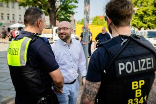 Brandenburgs Innenminister René Wilke mit zwei Polizisten in Brandenburg