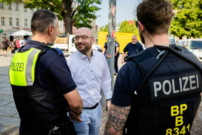 Brandenburgs Innenminister René Wilke mit zwei Polizisten in Brandenburg