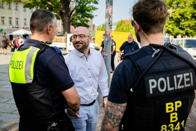 Brandenburgs Innenminister René Wilke mit zwei Polizisten in Brandenburg