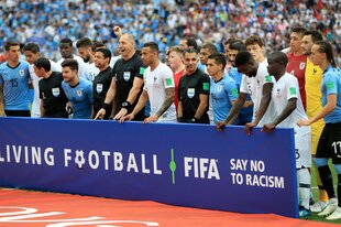 Zwei Fußballteams hinter einem Banner