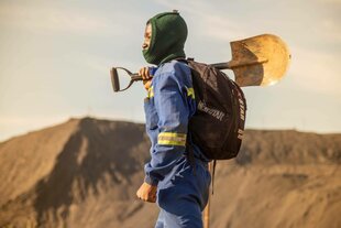 Ein Arbeiter in einer Kupfermine hält eine Schaufel