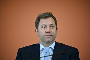 KLingbeil sitzt mit neutral-abwesendem Gesichtsausdruck in einer Pressekonferenz