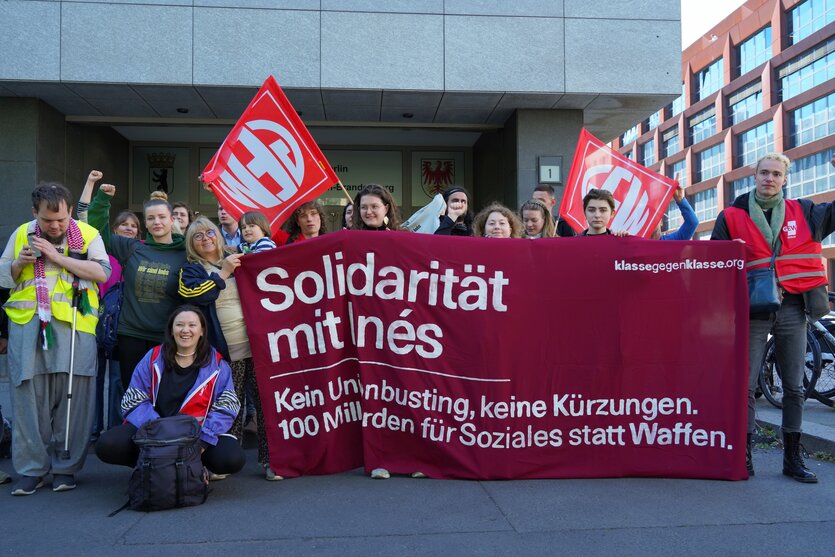 Eine Gruppe von Menschen steht mit einem Transpi mit der Aufschrift "Solidarität mit Inés" vor dem Berliner Arbeitsgericht
