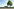 Neben einer einsamen Bushaltestelle steht ein Baum, im Hintergrund Himmel und Feld