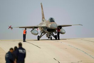 Mechaniker stehen auf einem Militärflughafen bei Eilat in Israel an einem F-16 Kampfjet der israelischen Luftwaffe
