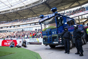 Die Polizei mit Wasserwerfer im Innenraum eines Fussballstadions