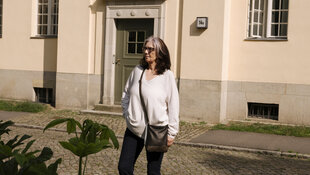 Porträt von Martina Blankenfeld vor einem Gebäude.