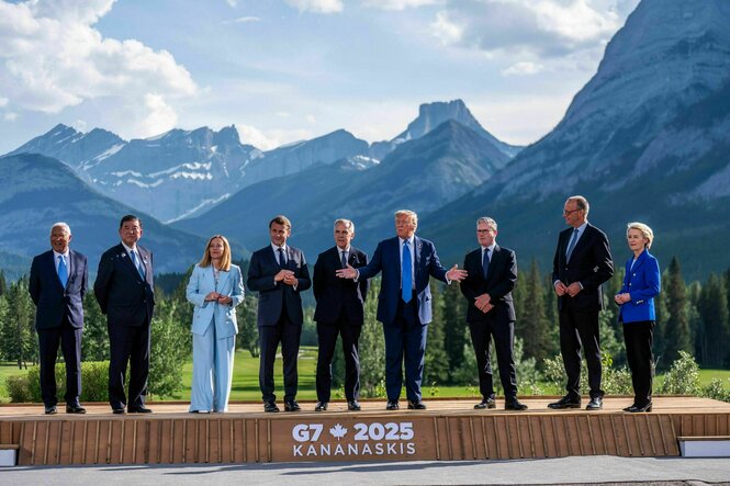 Neun Männer und Frauen stehen auf einem Podest für ein Foto vor der Kanadischen Bergwelt