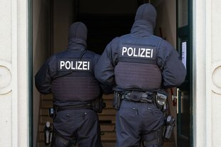 Zwei Polizisten von hinten in einem Hauseingang