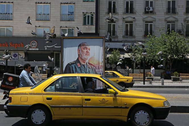 Gelbe Taxen und das Plakat eines Militärführers in Teheran