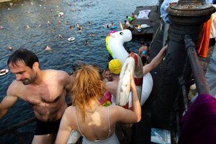 Menschen in Badetextilien gehen Schwimmen