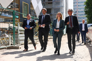 Vier Poltiker und Politikerinnen auf einer Baustelle