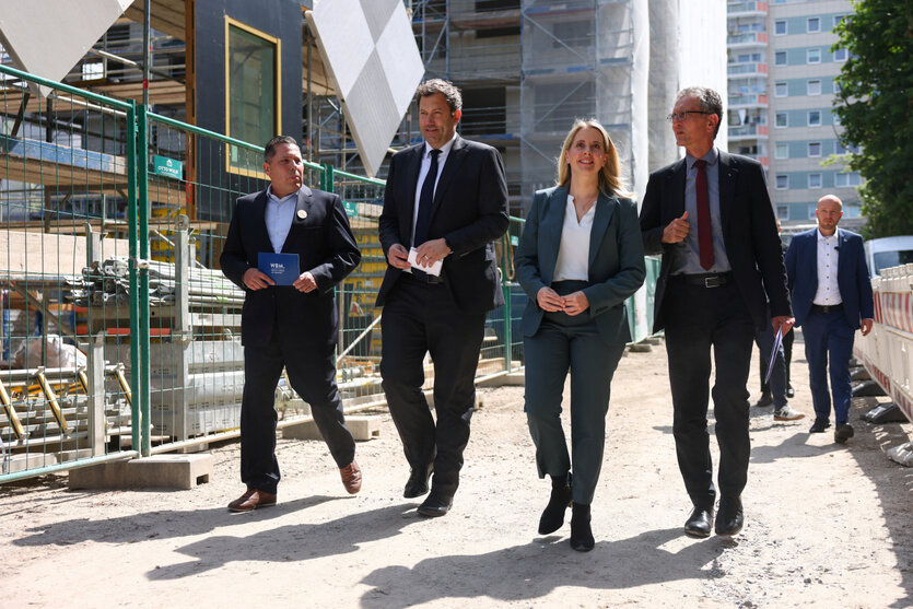 Vier Poltiker und Politikerinnen auf einer Baustelle