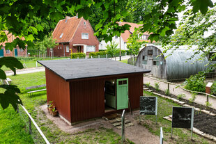 Eine rote Holzhütte, daneben eine 
