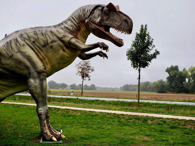 Eine Dinosauerierstatue an einer Straße.