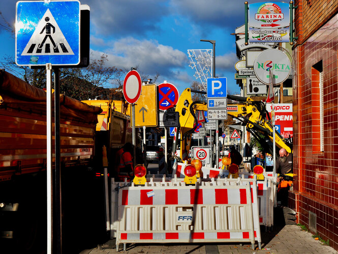 Straßenszene mit sehr vielen Schildern.