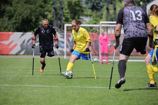 Ein beinamputierte Frau am Ball bei einem Fußballspiel.
