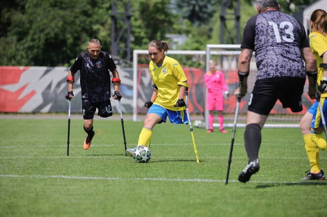 Ein beinamputierte Frau am Ball bei einem Fußballspiel.