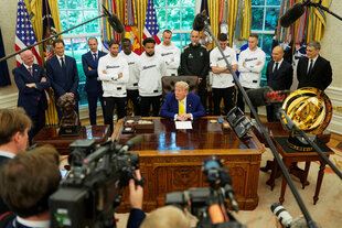 Donald Trump am Schreibtisch, im Hintergrund steht eine Delegation von Juventus Turin