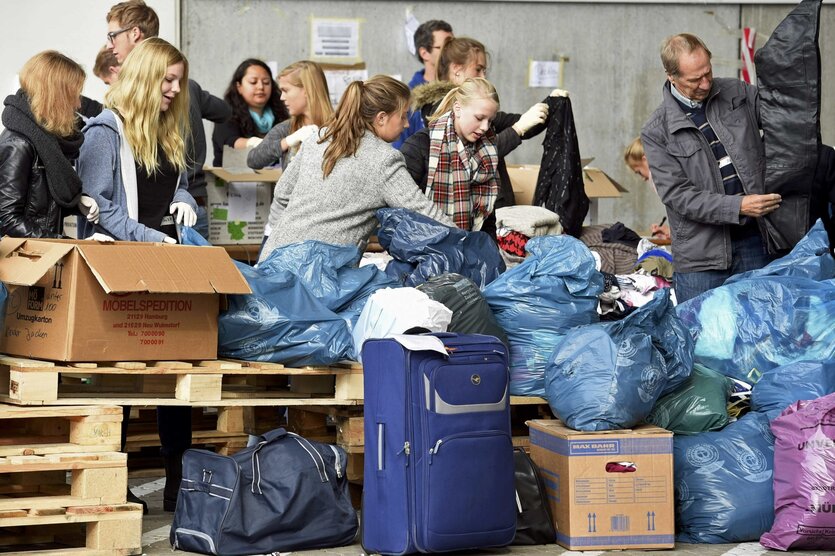 Junge Menschen kramen in großen Plastiksäcken