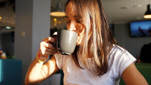 Eine Frau rinkt einen Kaffee