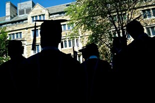 Studendierende der Universität Yale stehen bei der Abschlusszeremonie vor einem Uni-Gebäude