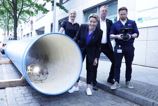 Menschen neben einer großen Röhre