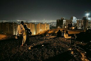 Menschen stehen auf einem Hügel und blicken auf die Lichter von Teheran