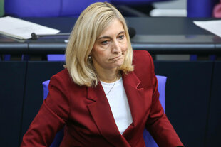 Eine Frau in rotem Jacket schaut skeptisch