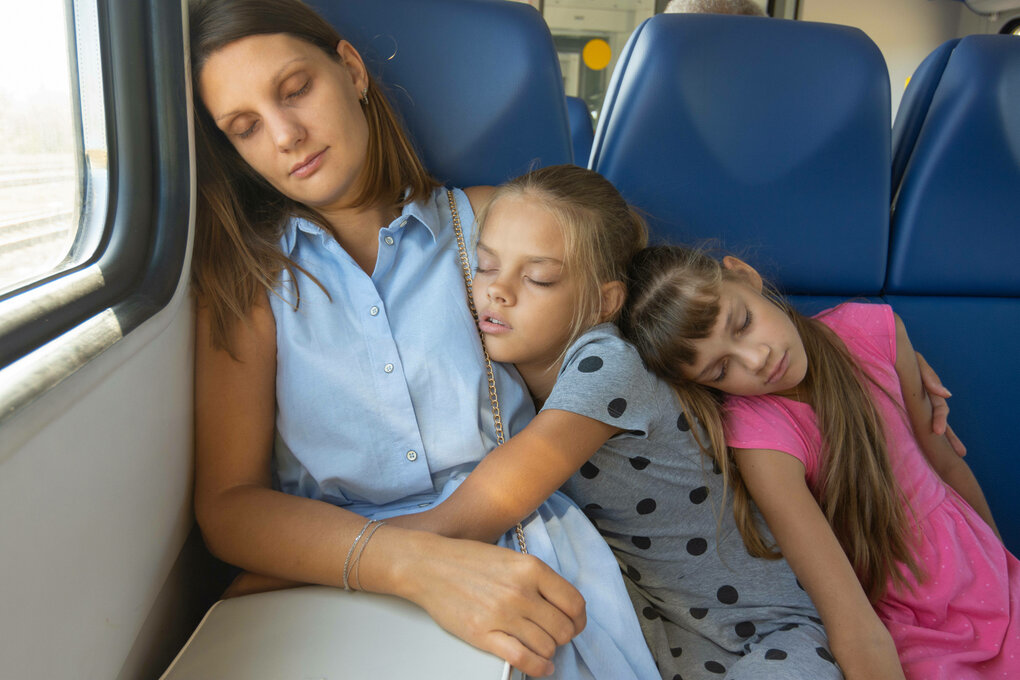 Eine Mutter mit ihren Kindern schlafend in Zug