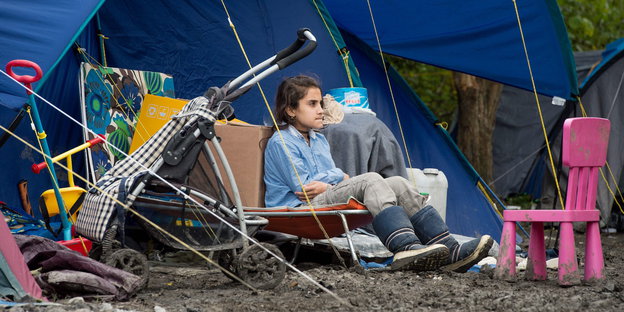 Mädchen sitzt vor einem Zelt