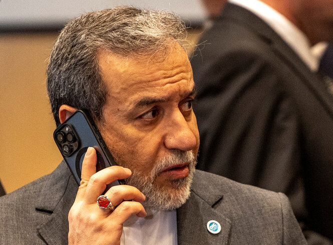 Abbas Araghchi mit einem Handy an seinem rechten Ohr