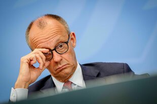Merz legt die Stirn in Falten und rückt seine Brille zurecht