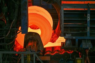 Eine glühende Rolle Stahl in einem Walzwerk