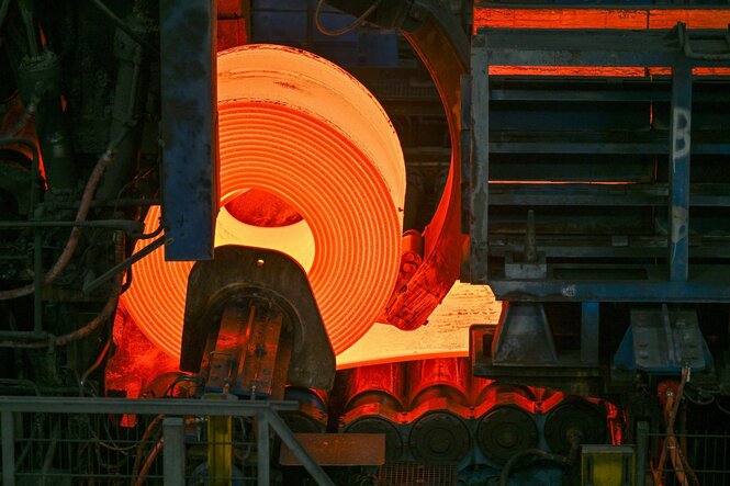Eine glühende Rolle Stahl in einem Walzwerk